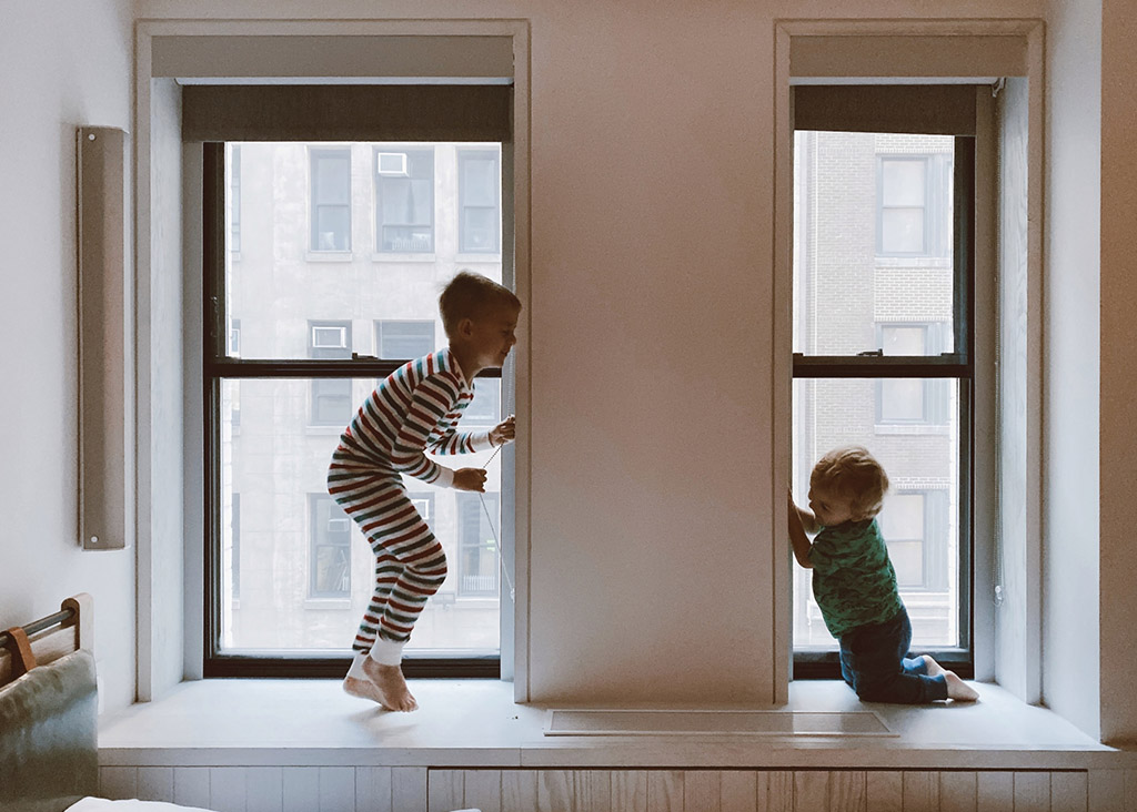Two children playing by the window