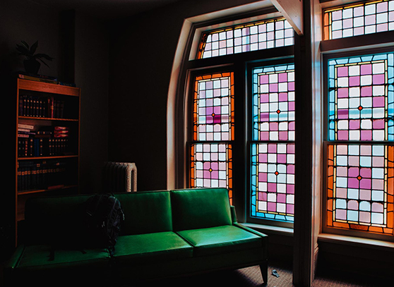 Vintage stained glass windows beside a green couch