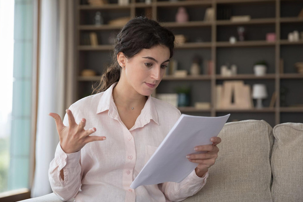 A homeowner reading the terms of her warranty on windows   